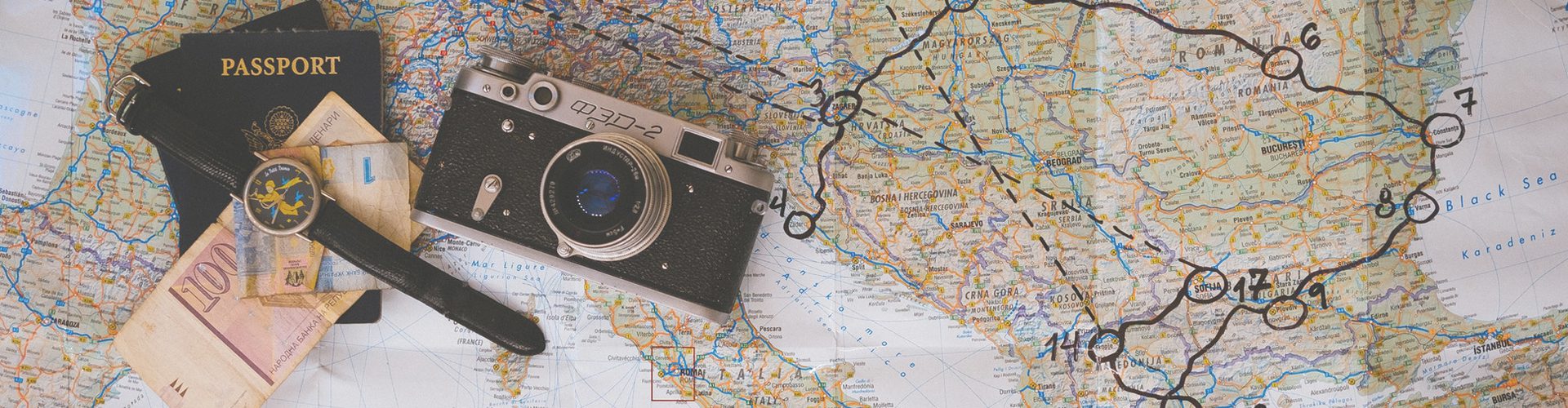 saving money - cash and passport on a map