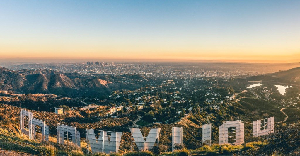 LA skyline at sunset from behind the sign.