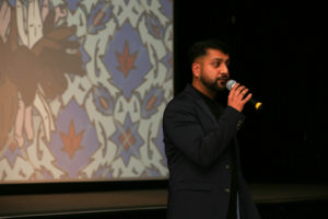 Riz giving speech at event