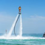 man-and-daughter-flyboarding-above-jet-skis