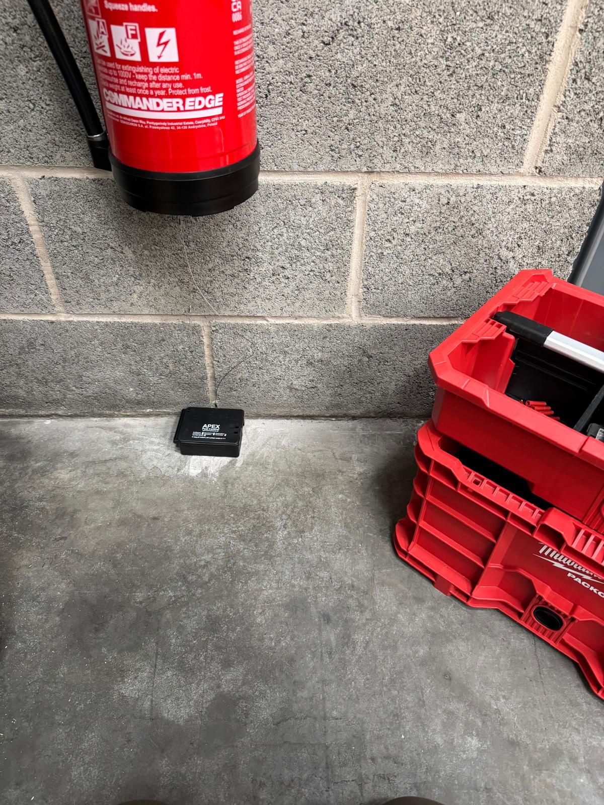 Rodent bait box placed on commercial site floor as part of Apex Pest Control PPM contract