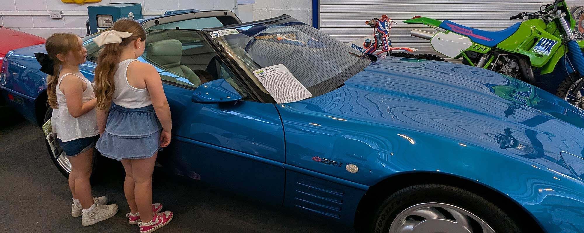 Two young girls look inside one of the museum's cars