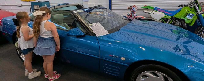 Two young girls look inside one of the museum's cars