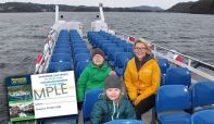 A family enjoying a cruise on Windermere with a super-imposed image of a residents card.