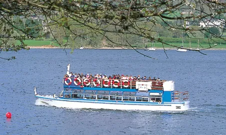 Silverholme cruising past Lakeland Pier spring blossom.