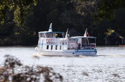 Miss Lakeland passing quaint boathouses
