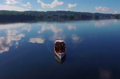 Tradiitional wooden launch on a glass-like Windermere