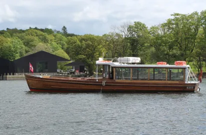 Beautiful tradtional launch gliding past Windermere Jetty Museum