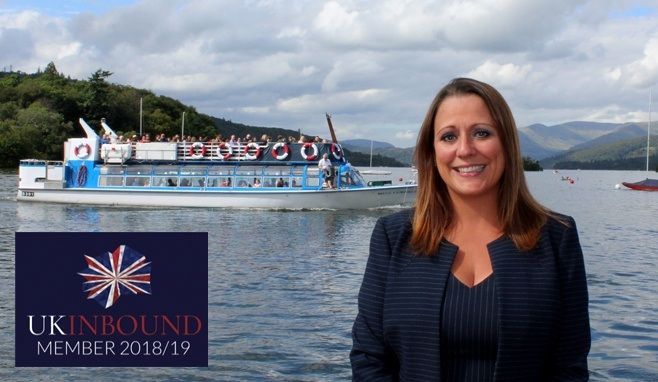 Jen Cormack on the Windermere shoreline with a launch (boat) behind her.