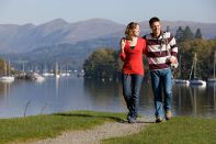 A couple walking along the shores of Lake Windermere