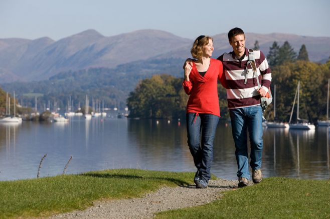 A couple walking along the shores of Lake Windermere