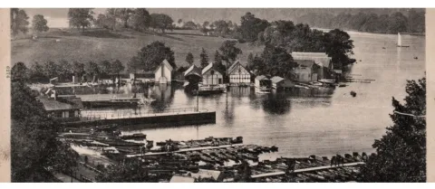 A photograph of early Bowness Bay with piers, boats, rowing boats and boathouses.