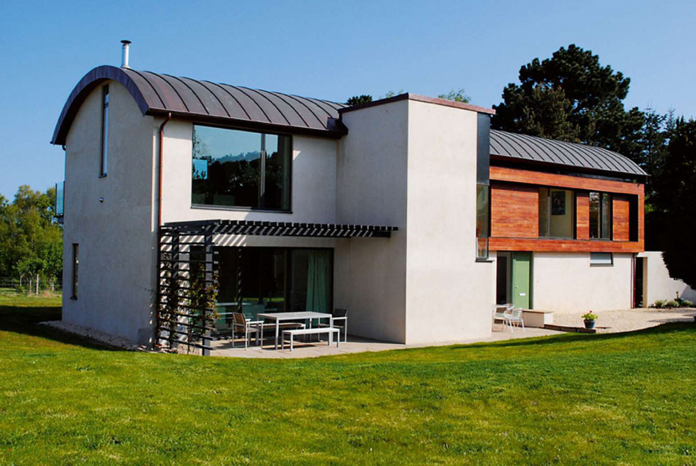 This Modernist home features a copper barrel roof