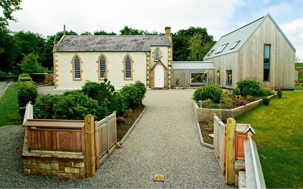 A converted stone church with a timber clad extension