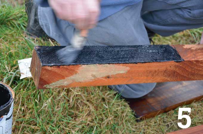 Brush on a couple of coats of bitumen-based paint on all sides and at the base of the post