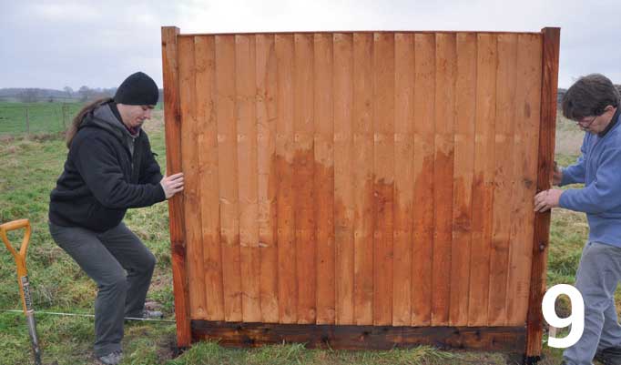 Lift the fence panel into position