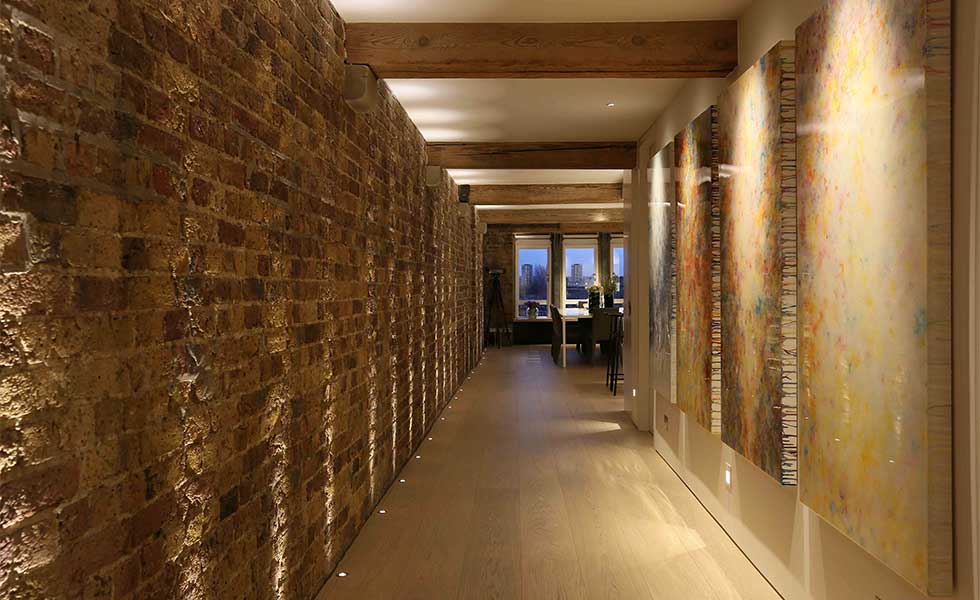 Hallway with low ceilings and uplighters from John Cullen
