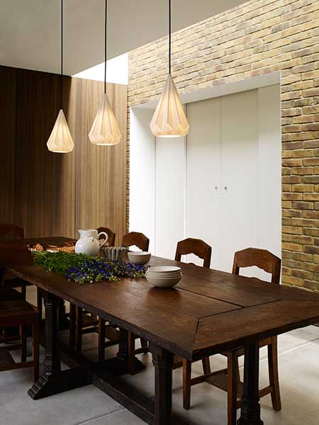 Long wooden dining table with pendant lighting