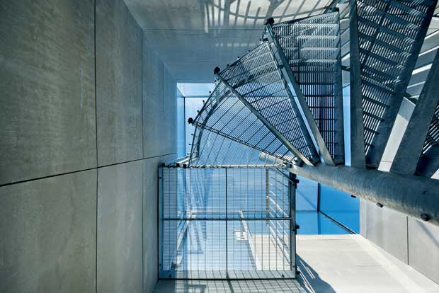 Industrial style spiral stairs serve as the main entrance