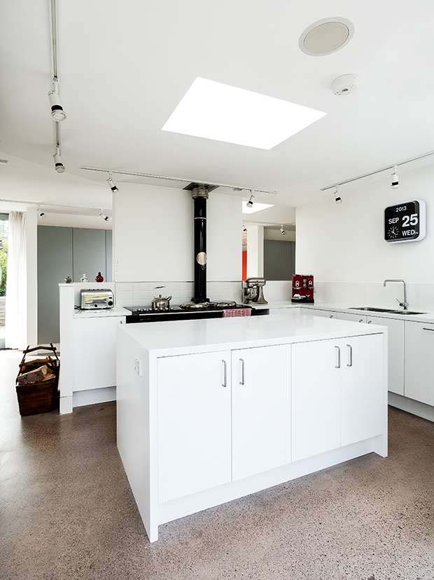 White Ikea units and Corian worktops create a sleek modern kitchen