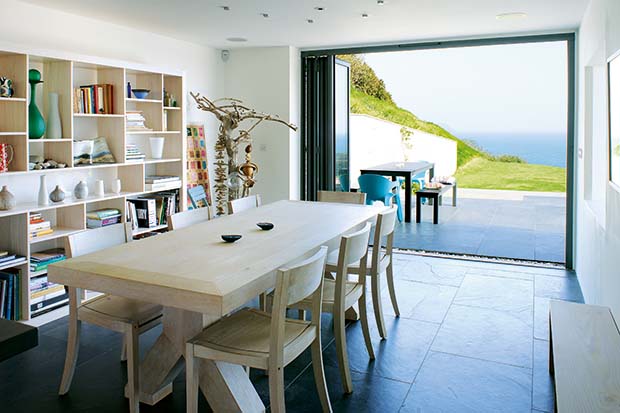 Dining room opening out onto a terrace in a hillside home