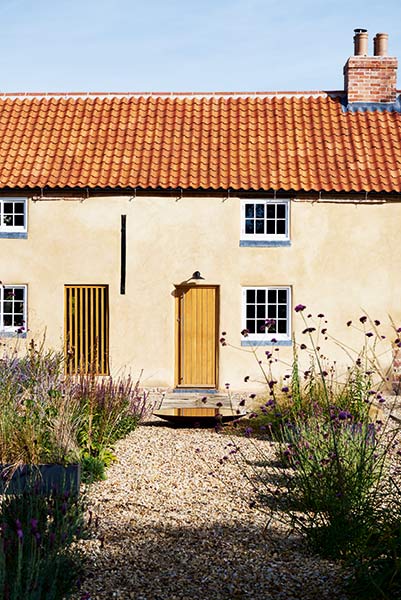 Listed cottage with cream render and clay roof tiles