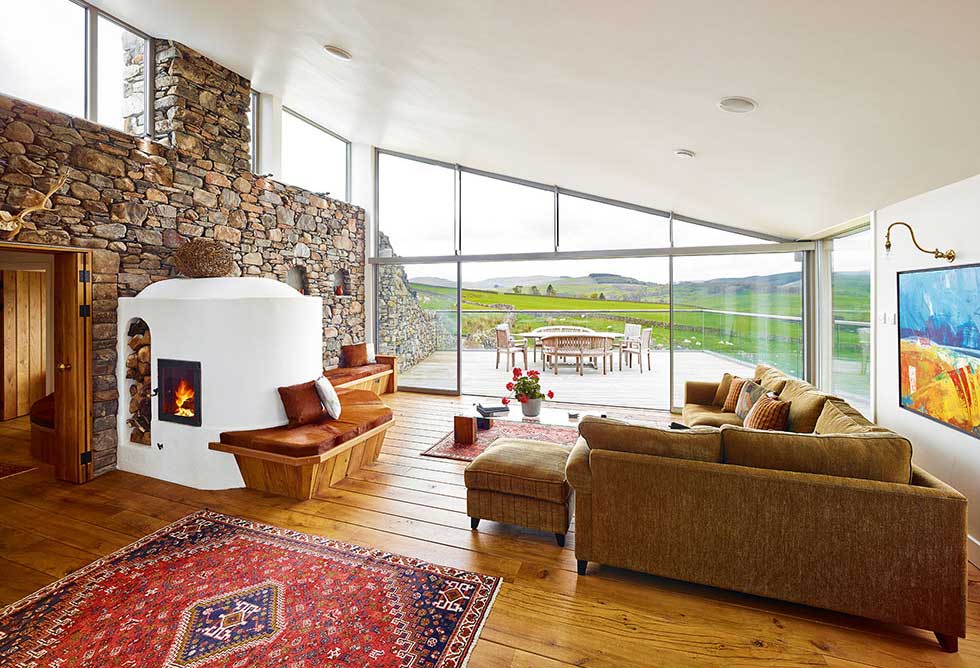 The stove in the main living area heats the dry stone wall that runs through the house