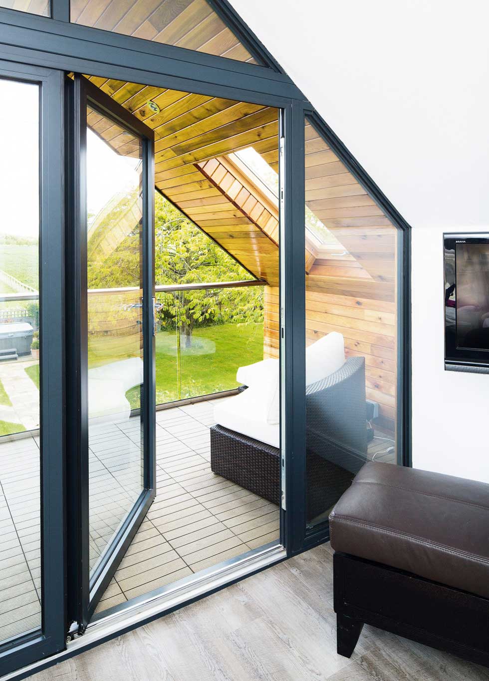 A glass door leads out onto the decked terrace