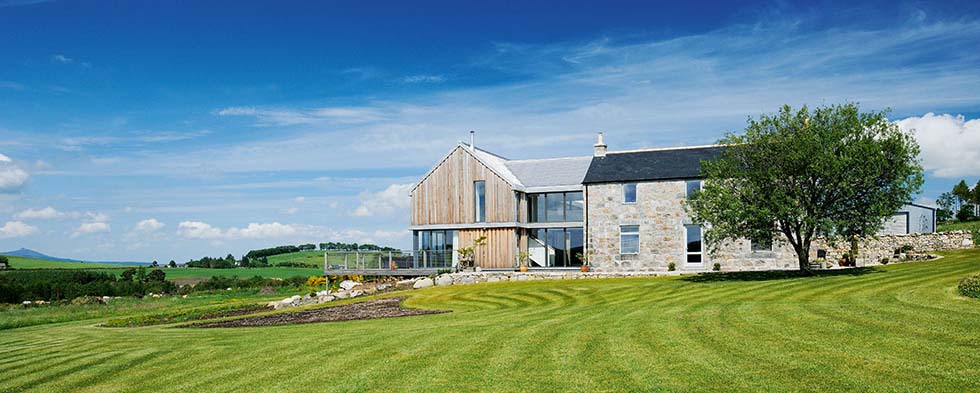 A granite farmhouse with a timber clad extension