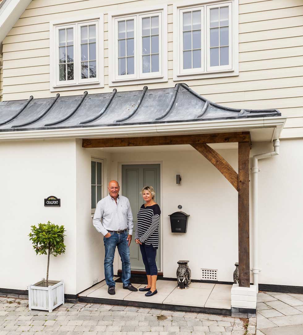 Jon and Sheila Osborne outside their remodelled New England-style house