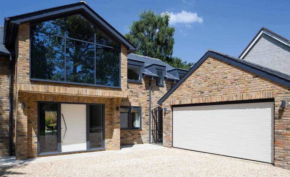 white garage door on garage attached to brick fronted house with glazed elements