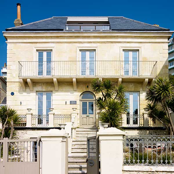 This seafront Georgian villa with banded cut stone façade has been expertly restored
