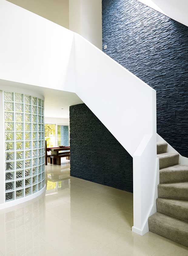 Curved glass wall seperates the living area from the entrance hall
