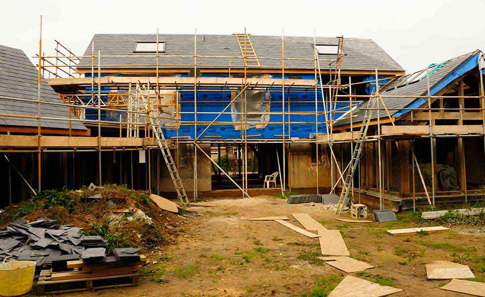 slated roof and hempcrete oak frame house surrounded by scaffold
