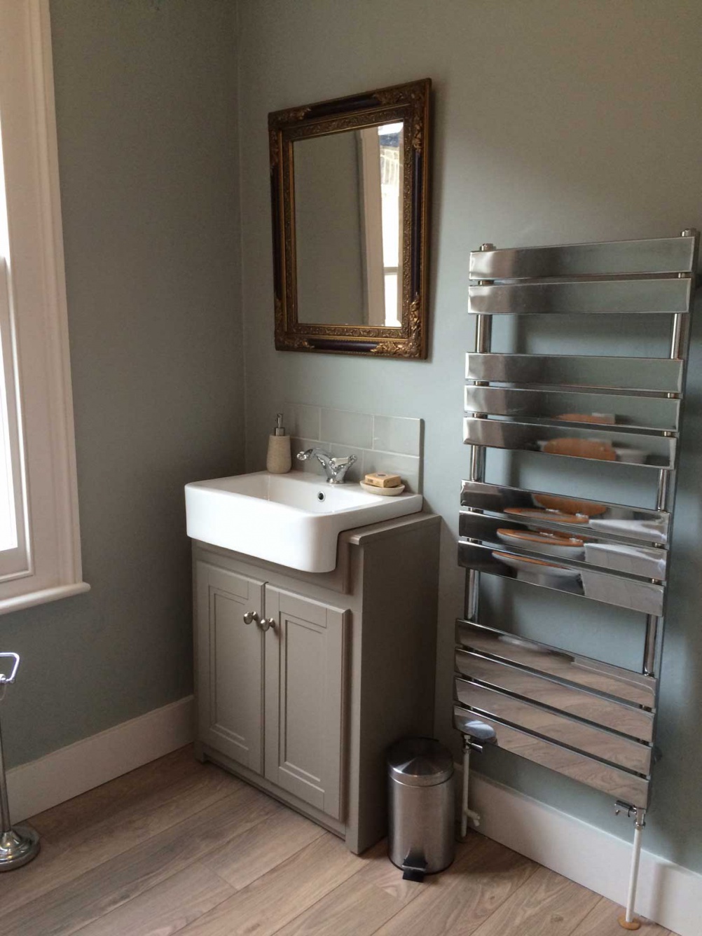 bathroom with blue-green walls and stone coloured vanity unit