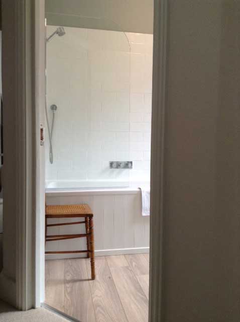 bathroom with over bath shower and glass screen