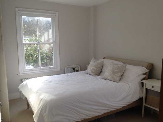 master bedroom with sash windows and white decor