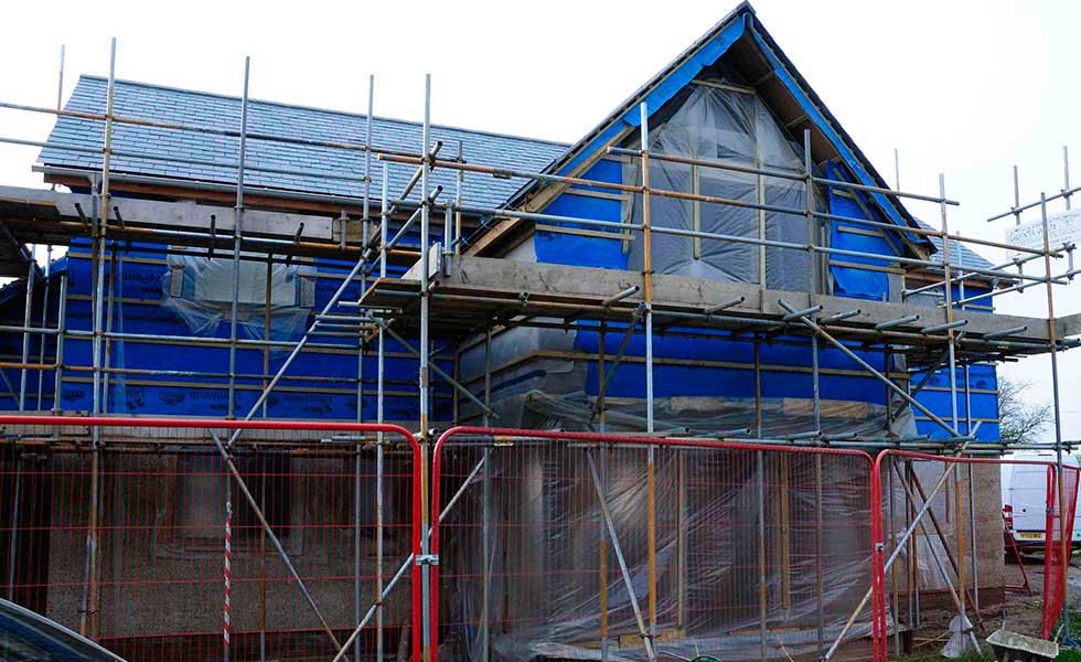 north elevation of oak frame home with plastic windows and scaffolding