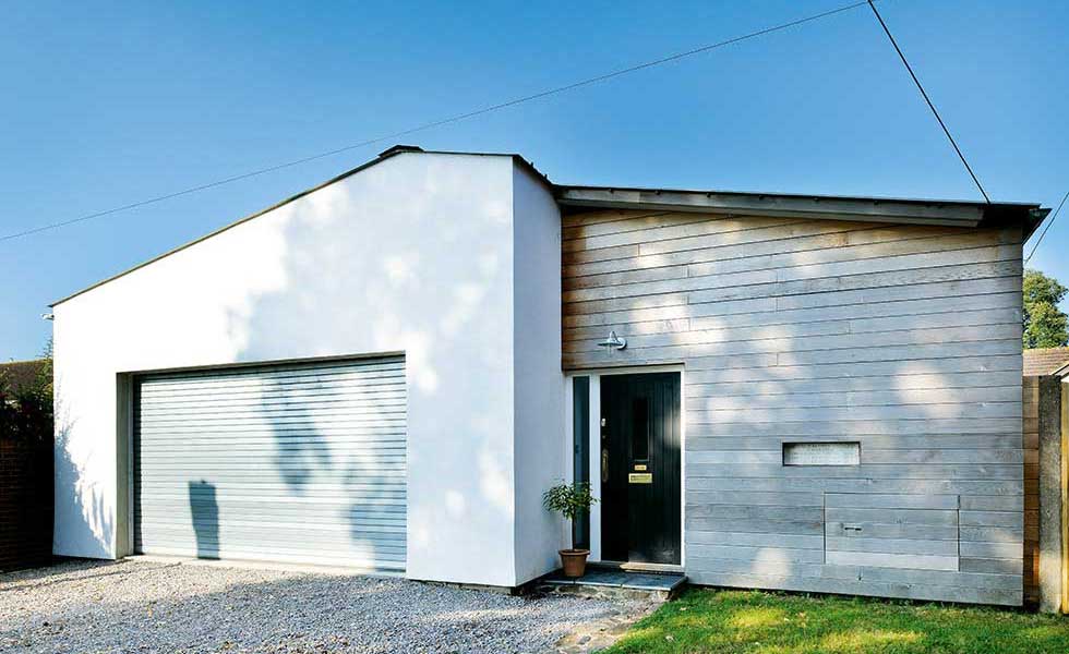 exterior of converted youth club in Devon with white render and timber cladding