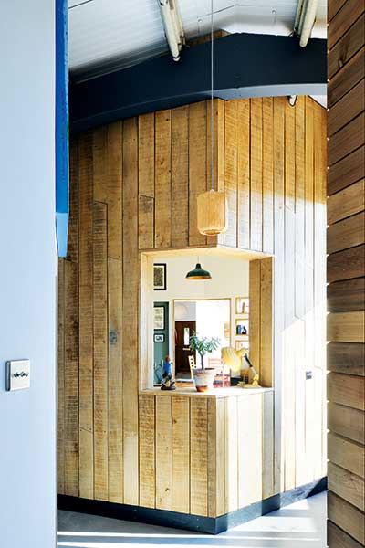 wood clad corner wall with window between living spaces