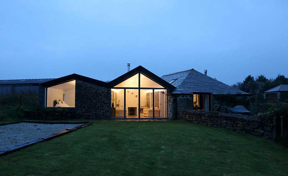evening shot of stone cottage with glass front