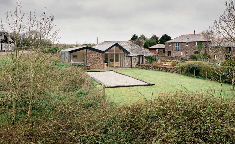stone cottage with glass front and garden