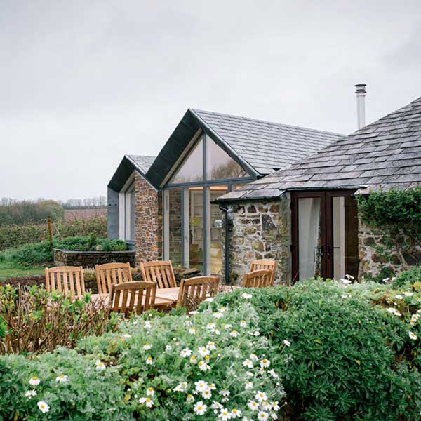 stone cottage with glass front and patio area
