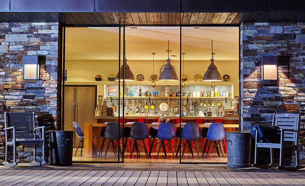 glass sliding doors overlooking large open plan living space with dining area and industrial style light fittings