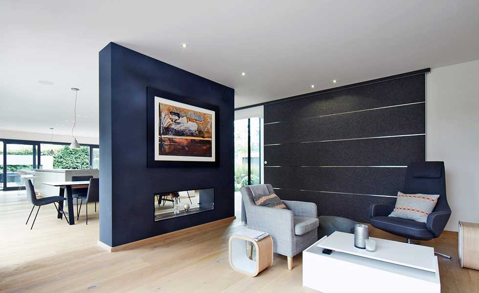 modern black open plan living space with grey armchairs