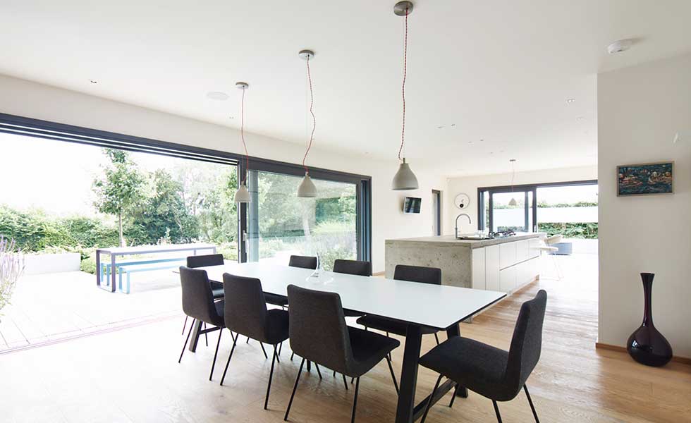 open plan dining space with large dining table and glass sliding doors