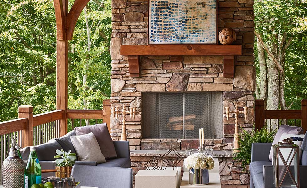 outside porch exposed brick fireplace with comfortable seating area