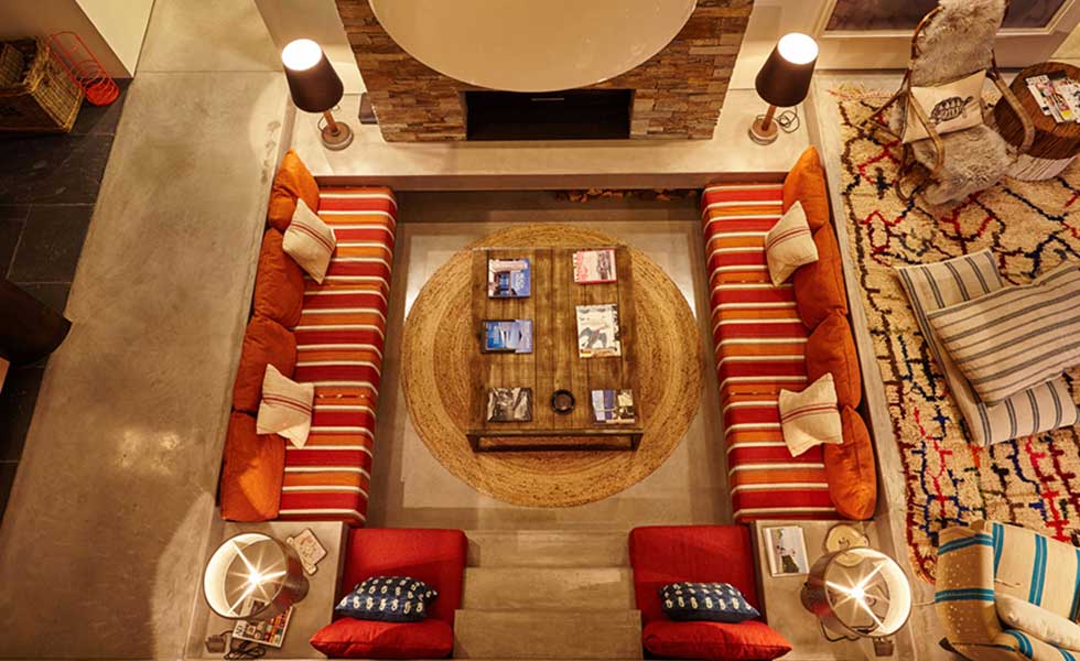 above shot of built in living space with red striped settees and large wooden coffee table