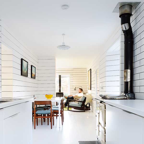 scandi style open living room with white panelled walls and wooden furniture