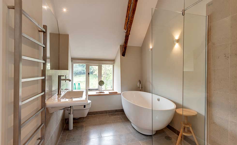 modern white bathroom with glass panelled shower and freestanding bath